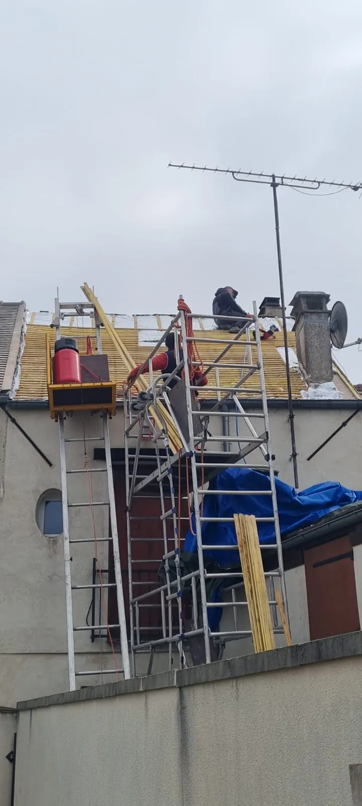 Monte-matériaux et échafaudage sur une réfection de toiture en ville